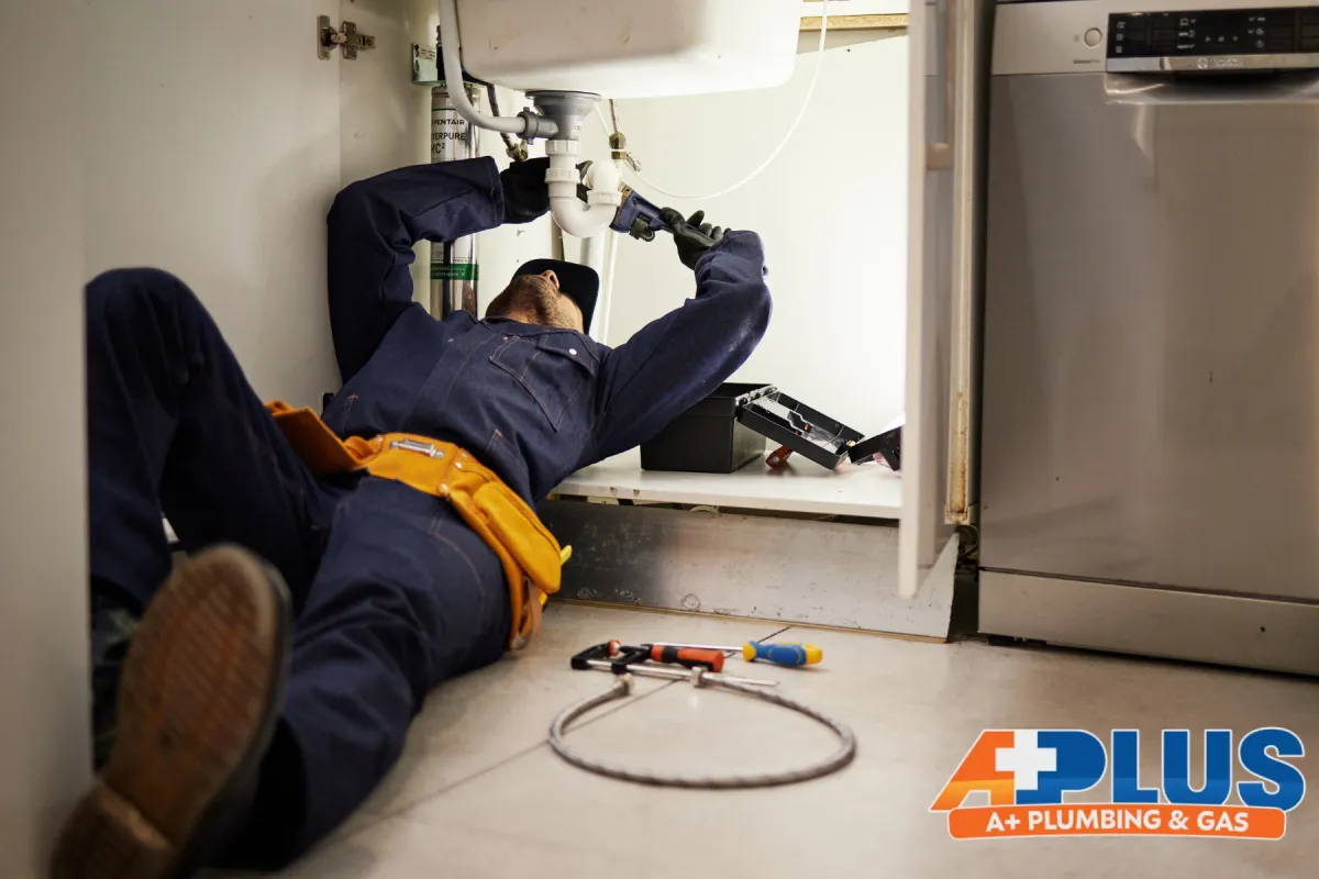 plumber working under the sink